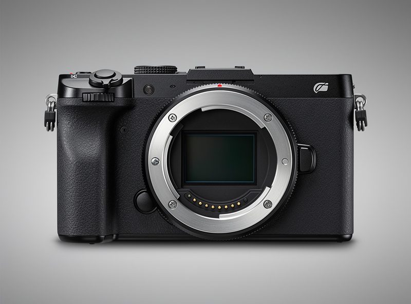Rear view of a mirrorless camera showing the metal lens mount with electronic contacts visible, ready for a lens to be attached