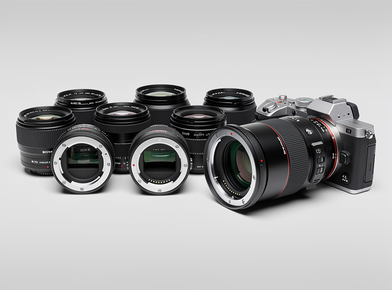 DSLR camera lenses mounted on a lens adapter ring connected to a mirrorless camera body showing the compatibility system