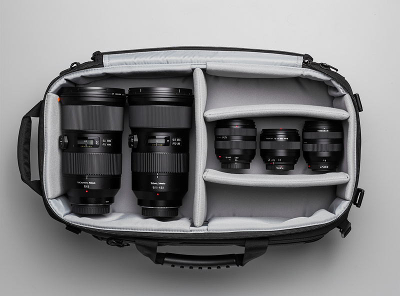 Two camera setups side by side showing a prime lens setup with three separate lenses versus a zoom lens setup with two zoom lenses covering the same focal range