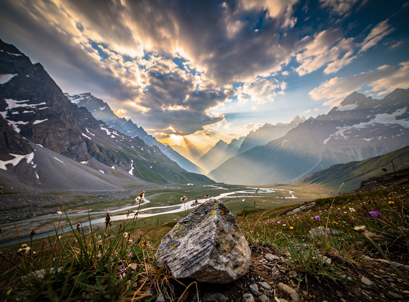 Ultra-wide angle landscape photograph showing dramatic foreground rock formation against expansive mountain vista, demonstrating the field of view of a 14mm lens