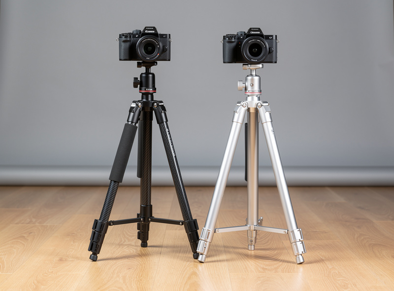 Side-by-side comparison of carbon fiber and aluminum tripods with mirrorless cameras