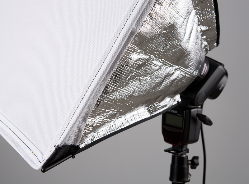 Collection of light modifiers including softbox, umbrella, beauty dish, and reflector in a home studio setup