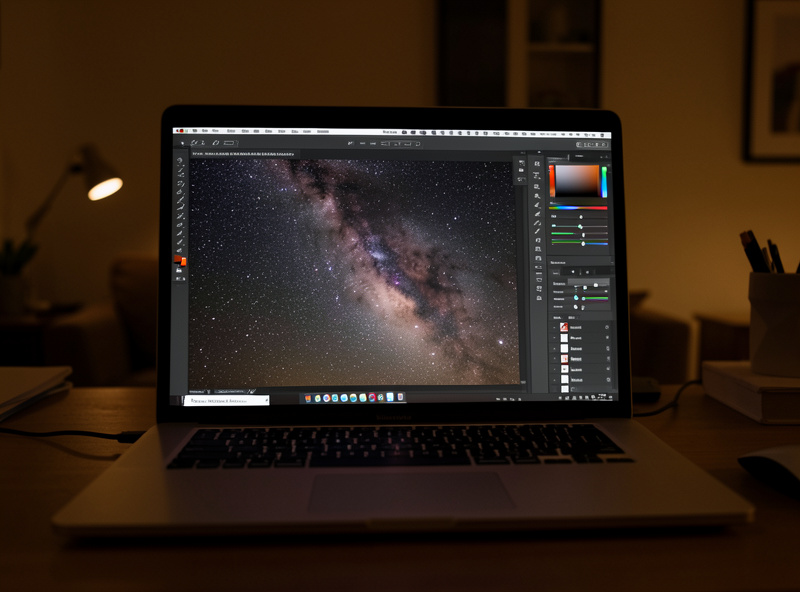 Editing a raw Milky Way photograph on a laptop showing before and after adjustments