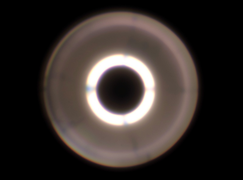 Single defocused point of light rendered as a bright-rimmed disc with a darker center