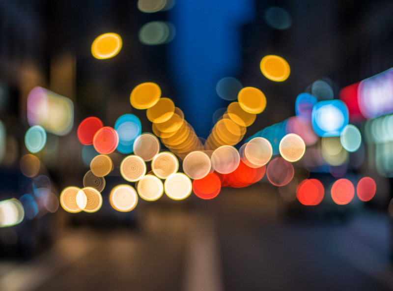 Night city street defocused into many large bokeh balls some showing faint internal ring texture