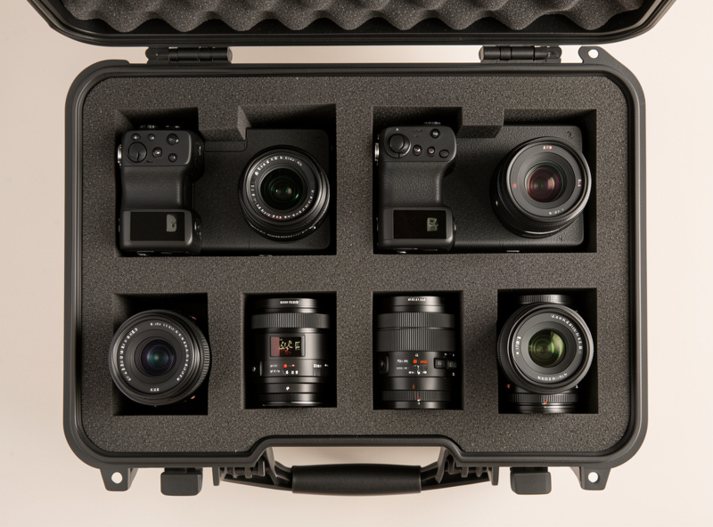 Two camera bodies and several lenses in a protective foam case, illustrating gear that needs insuring
