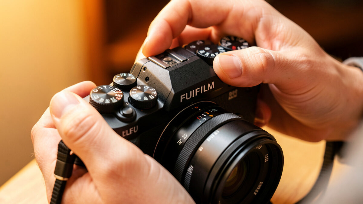 Photographer adjusting manual exposure on a mirrorless camera for video