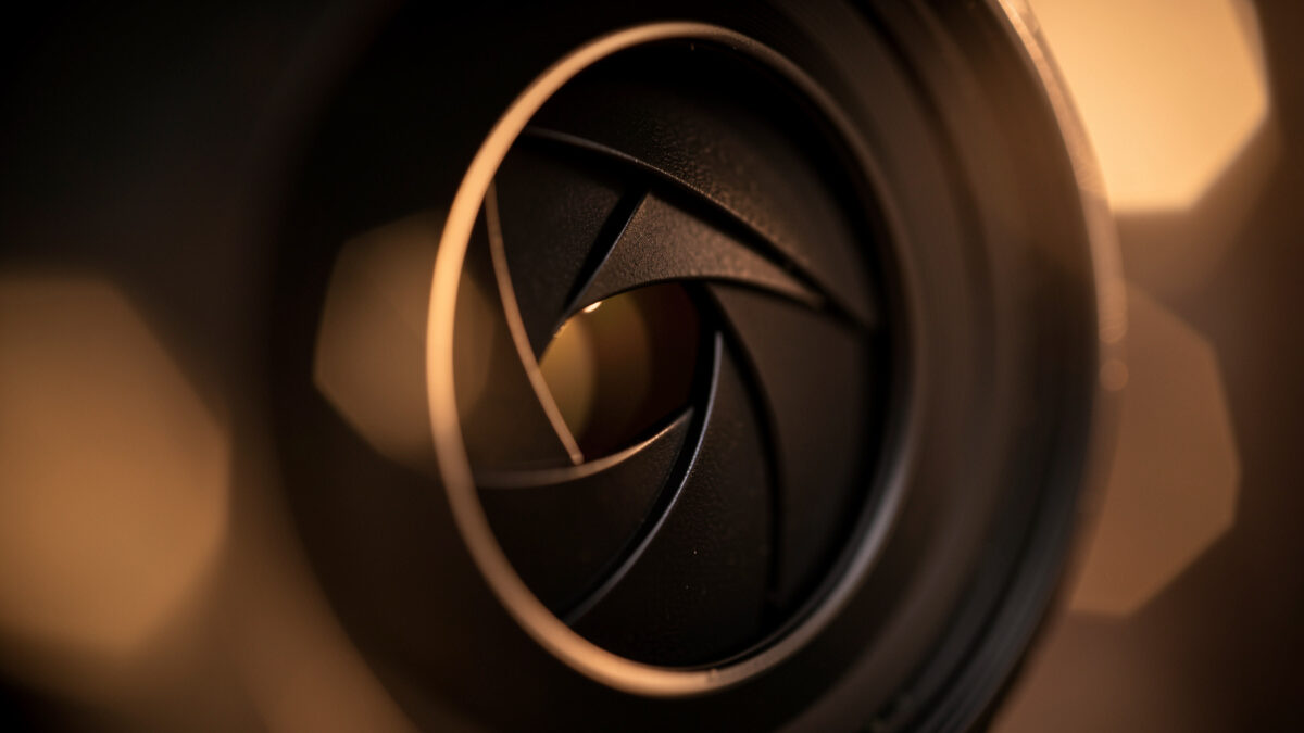 Lens aperture with rounded blades half closed next to out-of-focus polygonal highlights
