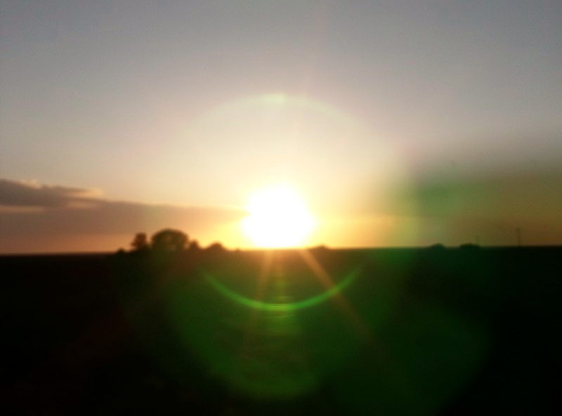 Backlit sunset scene through a camera lens showing veiling flare and ghosting caused by a front filter