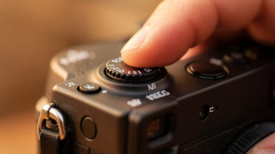 Photographer's thumb on the AF joystick of a mirrorless camera moving the focus point