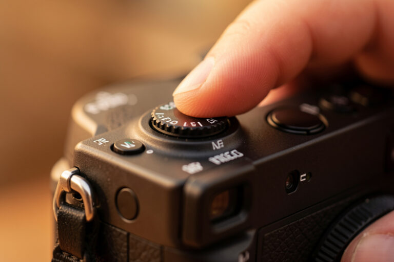 Photographer's thumb on the AF joystick of a mirrorless camera moving the focus point