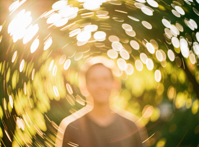 Backlit foliage rendered as a spinning swirl of highlights behind a subject at golden hour