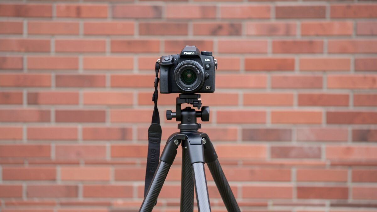 Camera on a carbon tripod aimed squarely at a flat brick wall for a decentering test