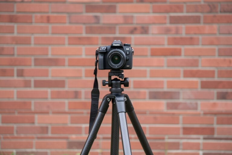 Camera on a carbon tripod aimed squarely at a flat brick wall for a decentering test