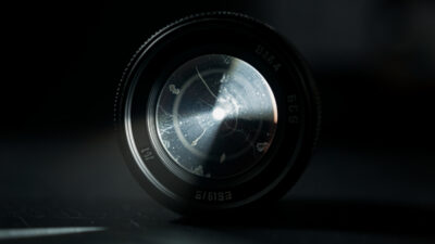 Camera lens lit by a single beam revealing internal contamination