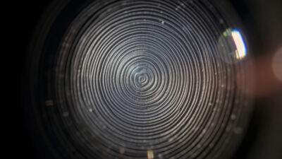 Bright out-of-focus highlights showing concentric onion-ring texture from an aspherical lens