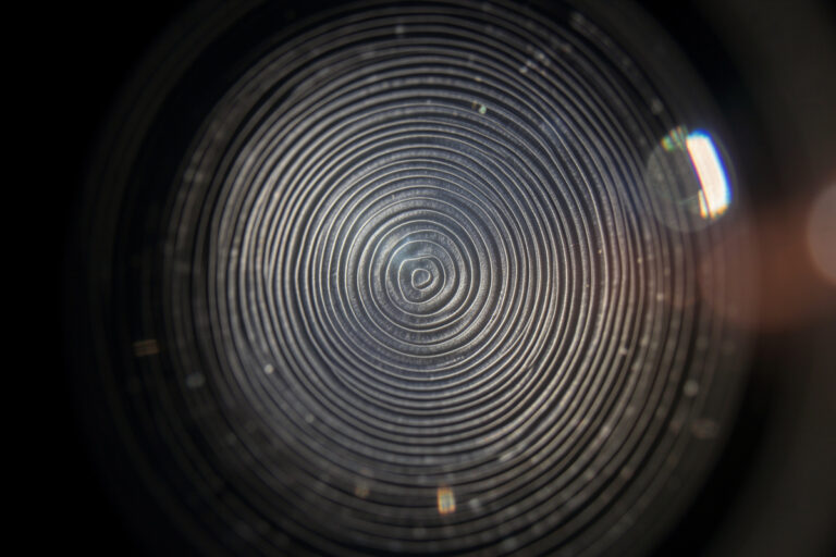 Bright out-of-focus highlights showing concentric onion-ring texture from an aspherical lens