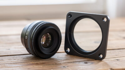 A screw-in filter beside a square filter holder kit on a bench