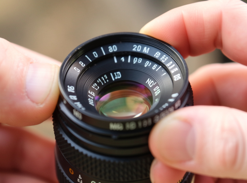A variable ND filter on a lens being rotated, with markings showing the density range from min to max